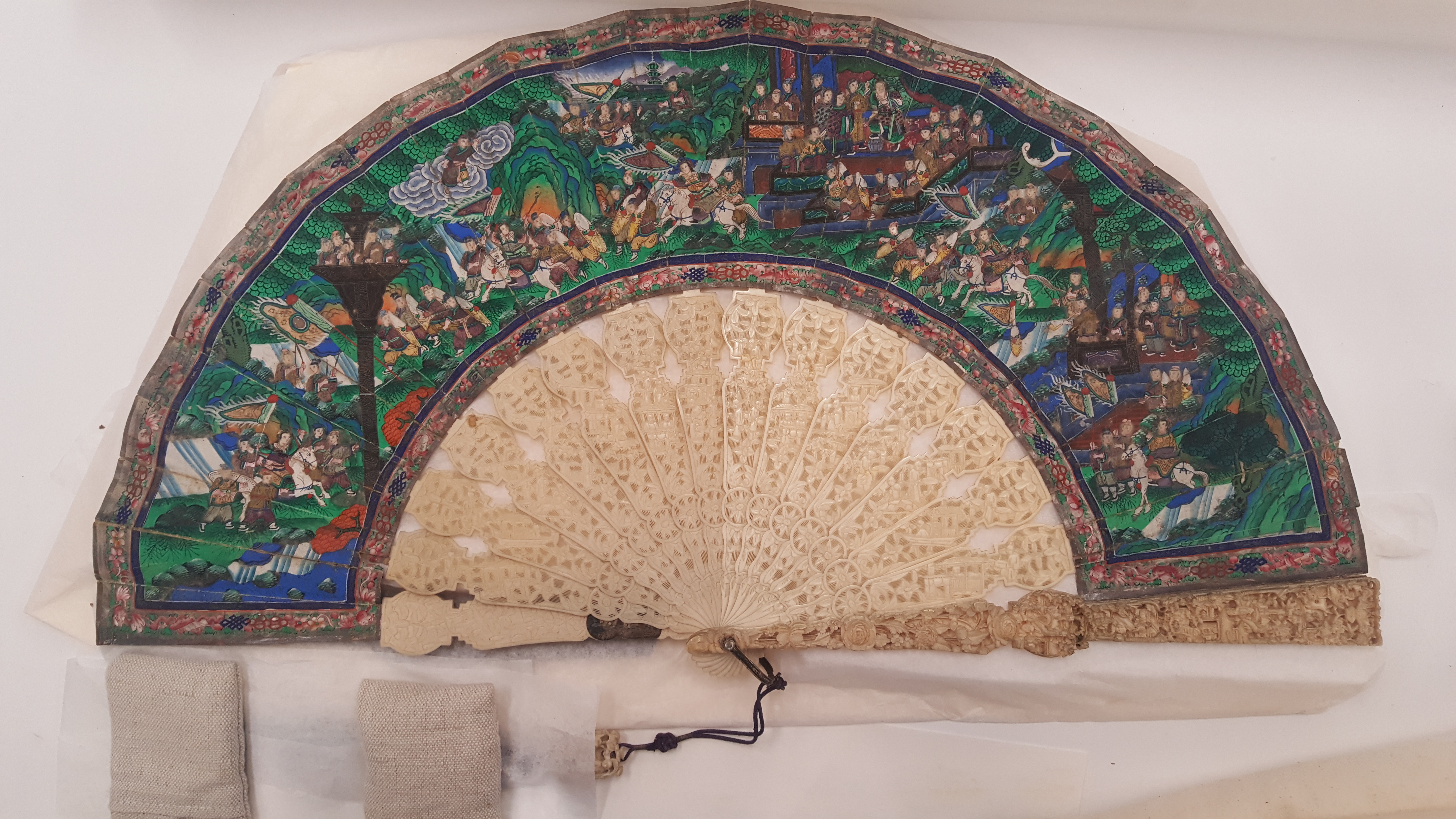 19th Century Chinese fan open during treatment of the ivory blades. The ivory blades on the left half (before treatment) appear dark and dull, while those on the right (after cleaning) are bright and glossy.